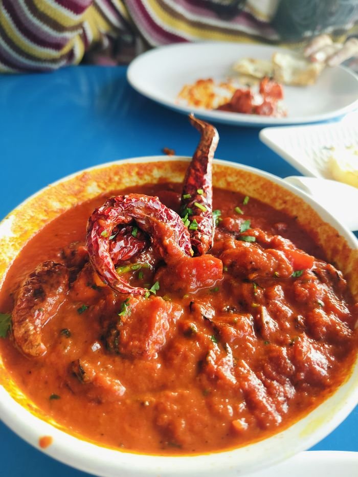Delicious spicy Indian curry with dried chilies served in a bowl.