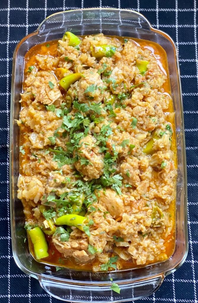 A mouth-watering homemade chicken curry with fresh herbs served in a glass dish.